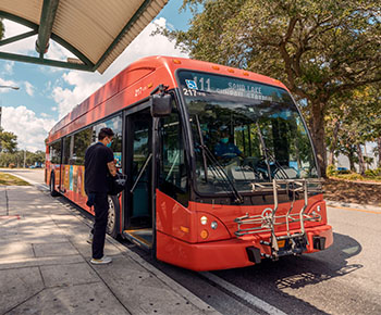 Guy entering red LYNX bus